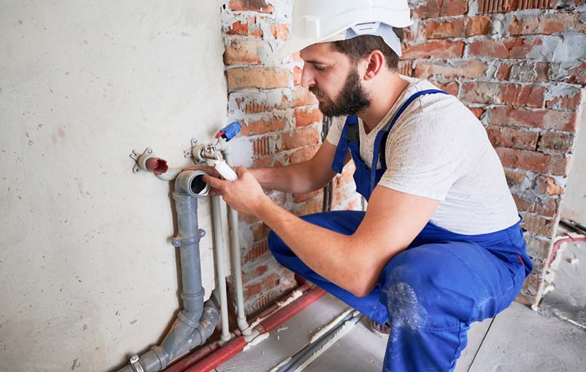 plumber fixing sewer pipe